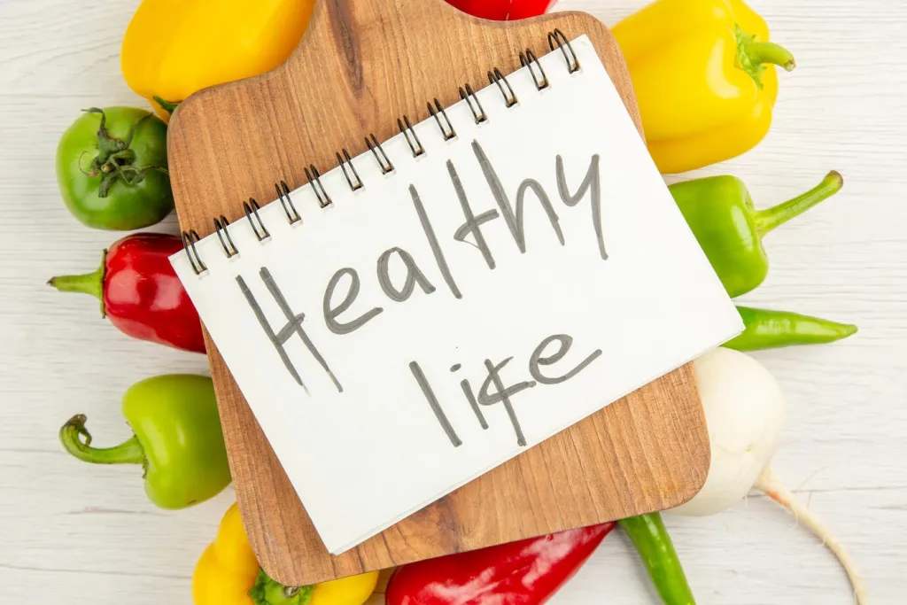 Top view fresh bell-peppers different colored with brown wooden desk