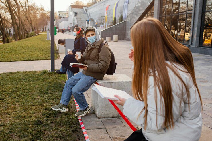 misogyny in nyc - two person holding a book wearing a mask talking to each other