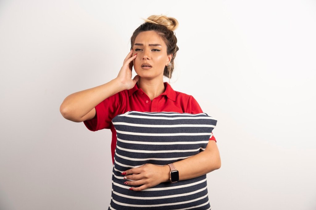 Woman in red shirt hugging a pillow
