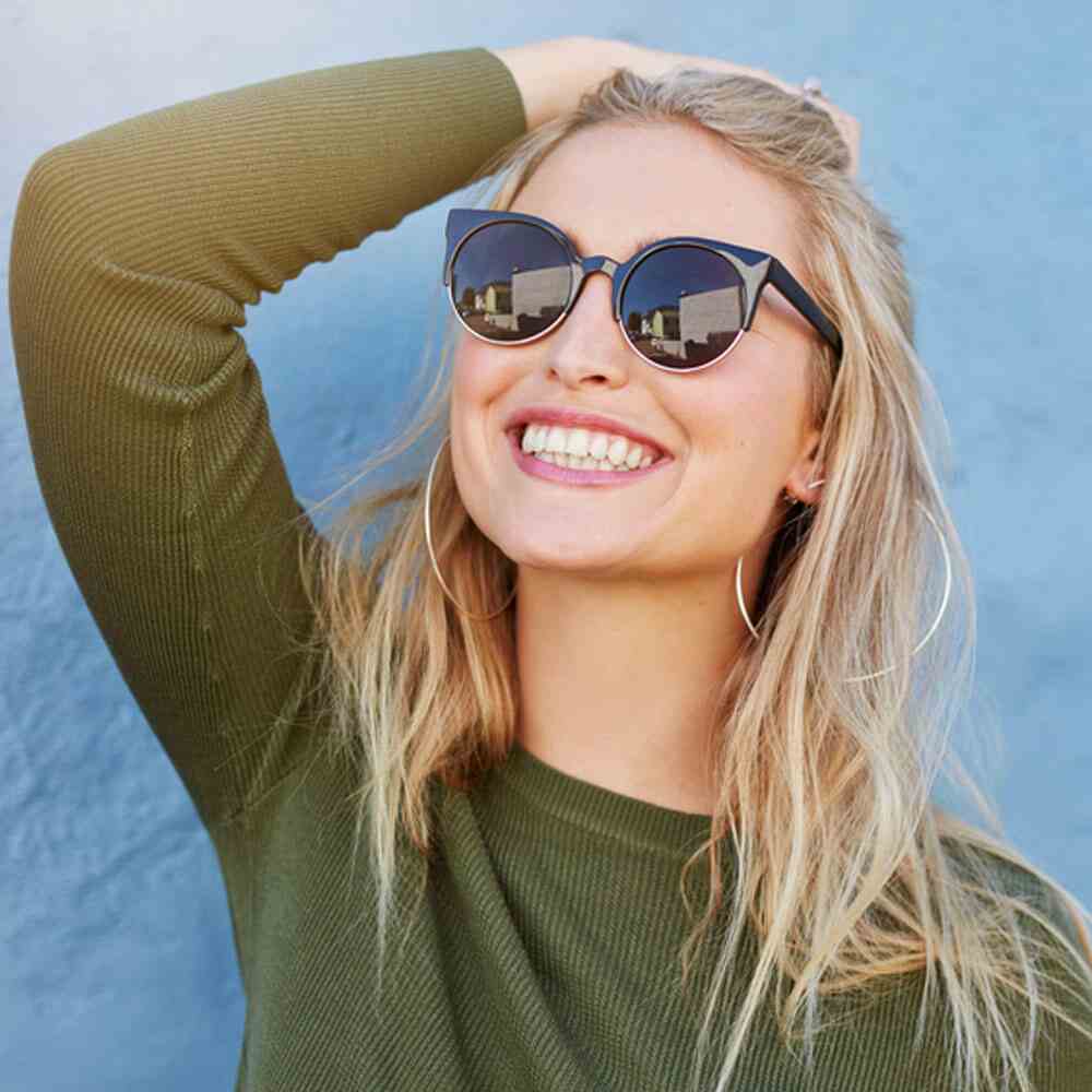 Person in a green top with blonde hair, manifesting success and happiness in NYC.