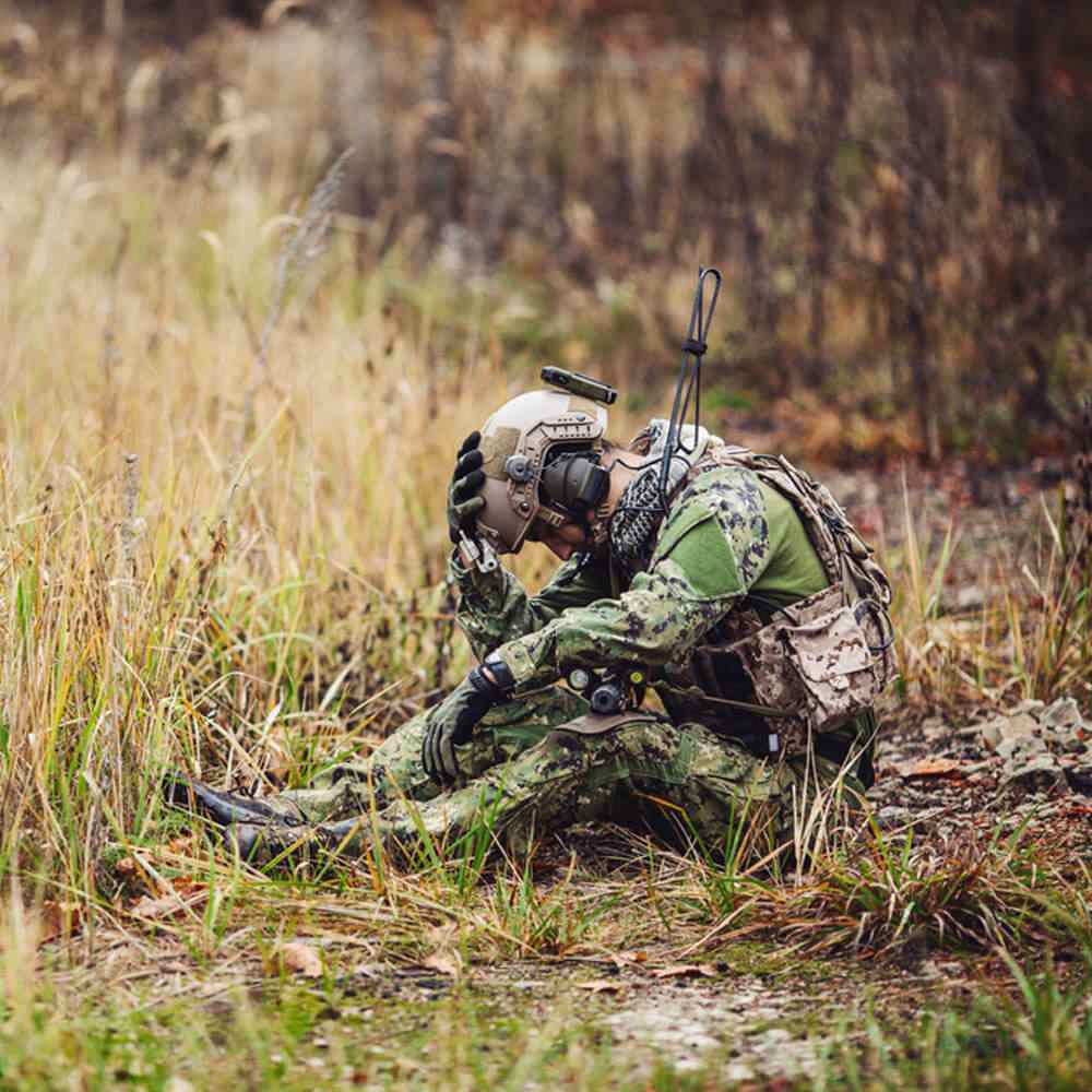 Soldier in camo gear in a field, exploring occupational therapy for PTSD in NYC.