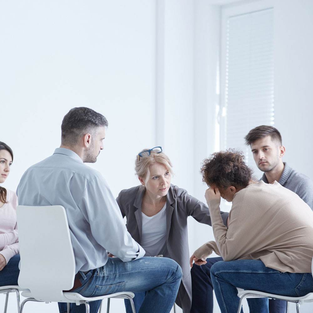 Group sitting in a circle discussing, using exposure therapy to overcome social phobia in NYC.