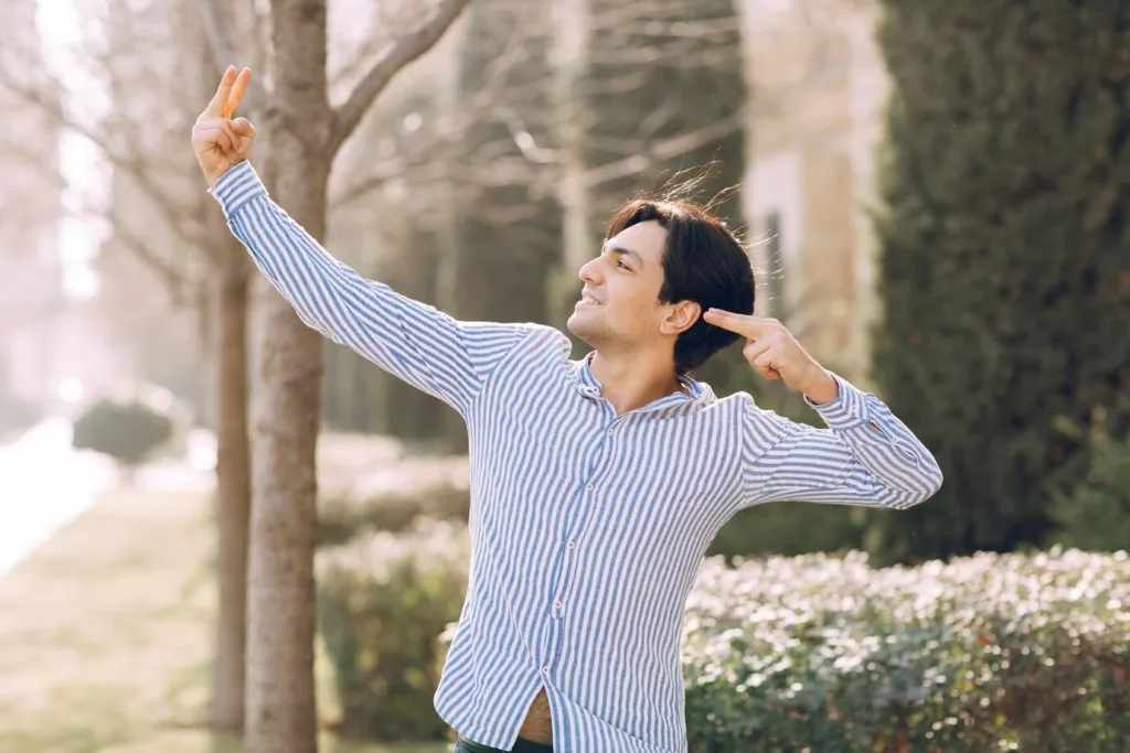 Man in the park pointing at something.