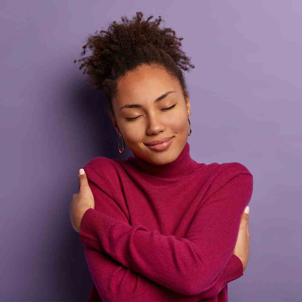 Person in a burgundy sweater, embracing self-care for mental health in NYC - Uncover Counseling.