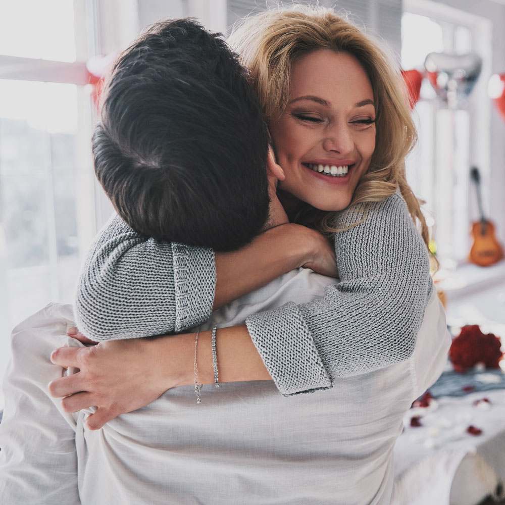 Two people embracing in a room with romantic items, celebrating love without overthinking in NYC.