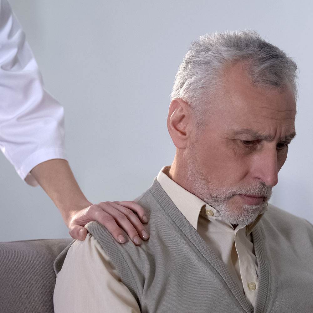 Person in a sweater receiving a shoulder pat, distress tolerance skills in DBT in NYC.