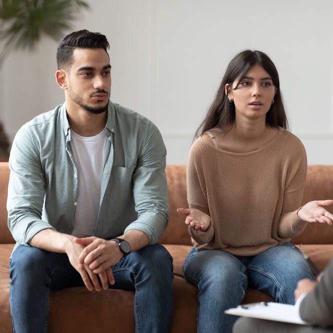 Serious young lady talking to psychologist counselor complaining on bad relationship with husband