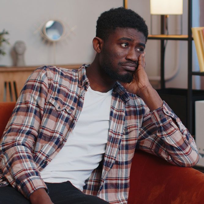 Man sitting at home looks pensive thinks over life concerns or unrequited love