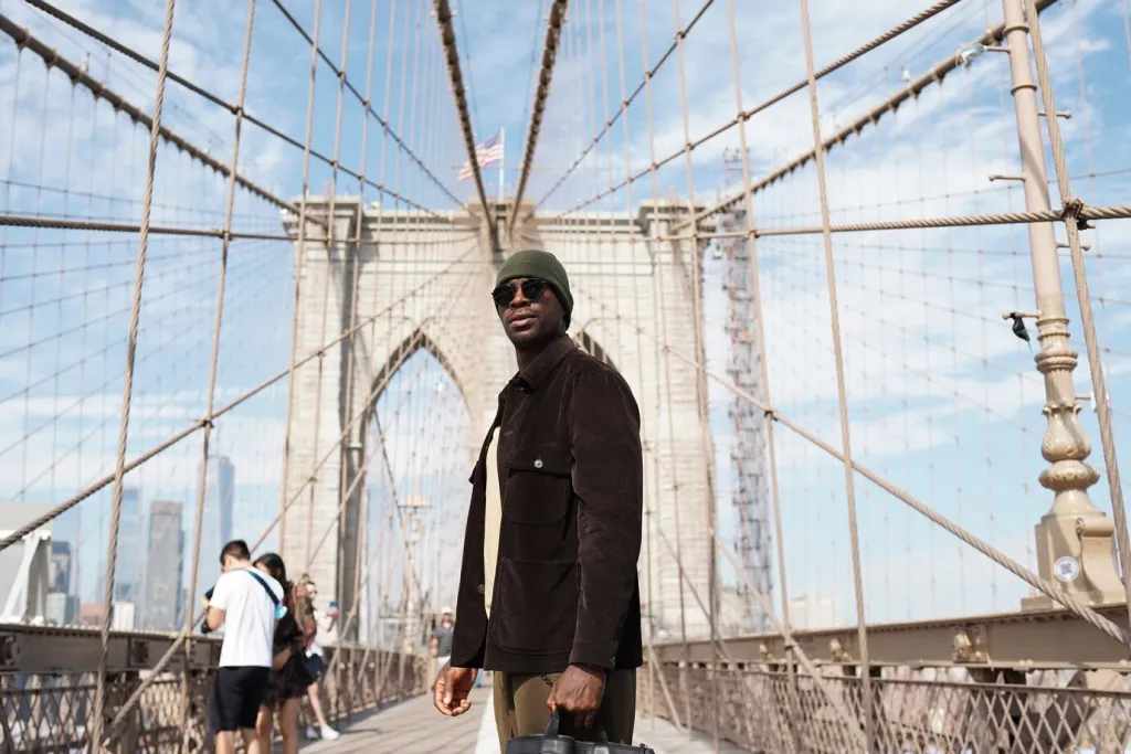 Young stylish man exploring a city bridge by himself