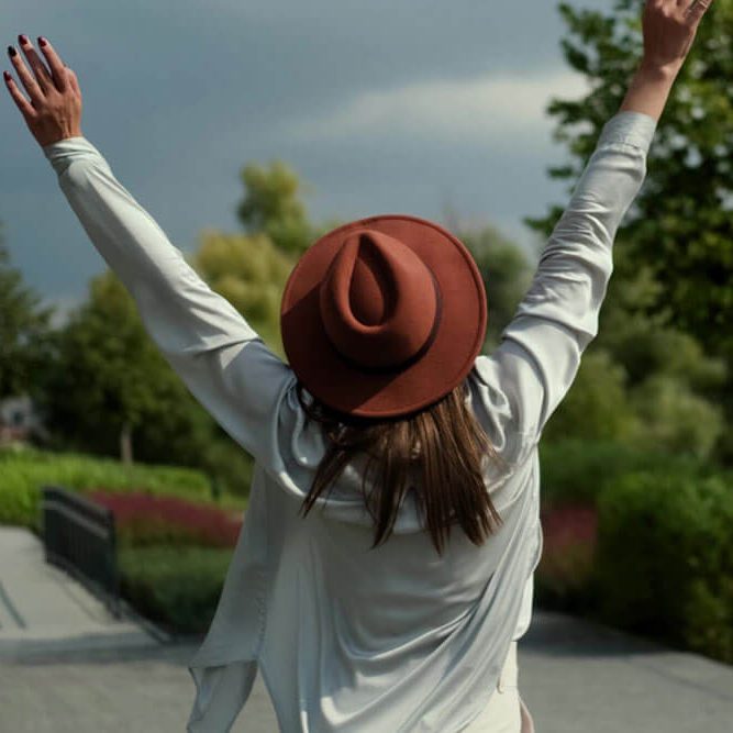 A beautiful smiling young woman walks in a summer park,