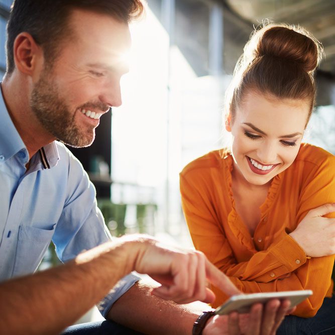 Couple in modern cafe enjoying time together browsing phone