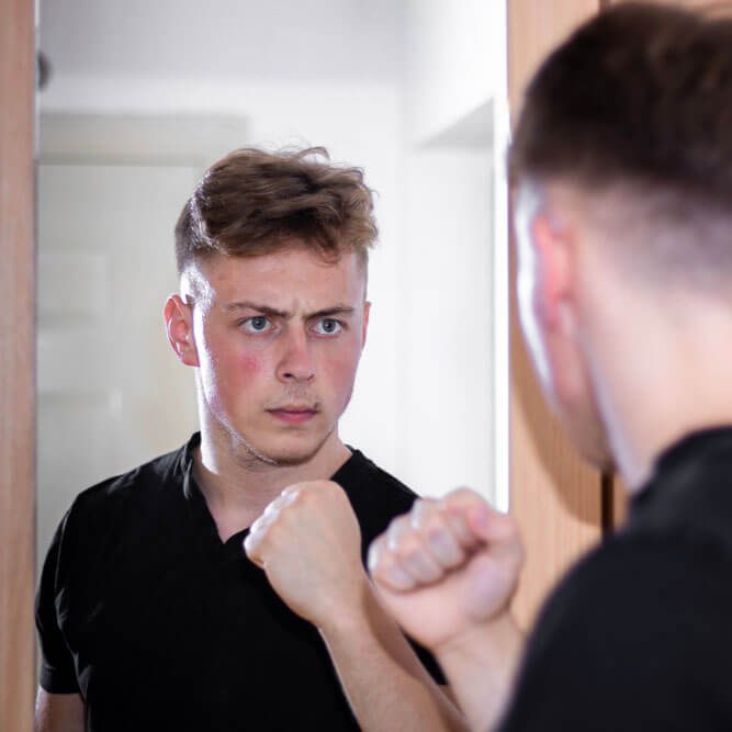 Guy looking at the mirror with raised fist. Trust yourself concept.