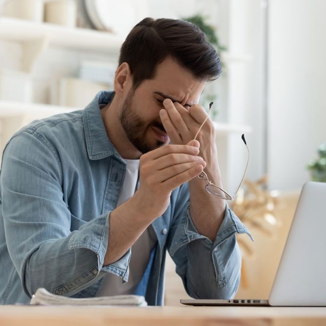 Stressed man suffer from headache bad vision sight problem sit at home table using laptop