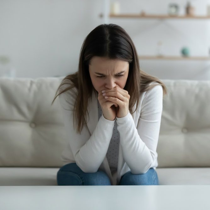 Woman feels depressed hopeless crying sit on sofa