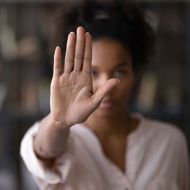 Close up focus on female mixed race palm hand showing stop sign