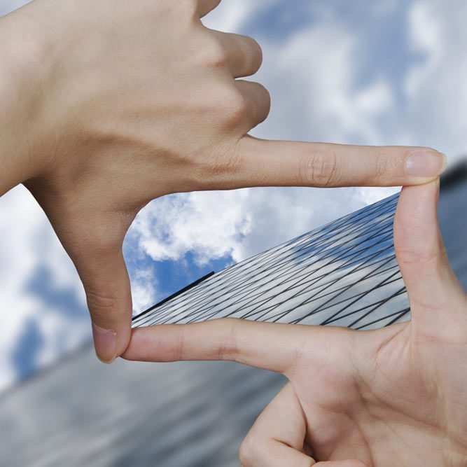 out of focus business building and fingers creating a square making the vision clear