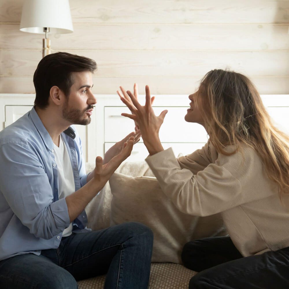 Two people playing a hand game on a couch, showing how to leave a toxic relationship in NYC.