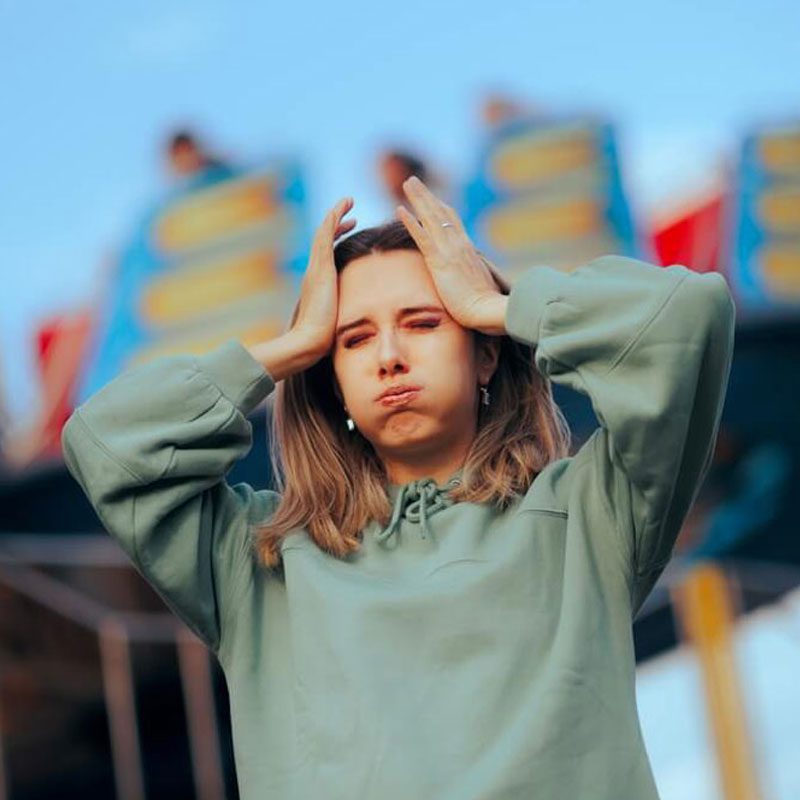 Person in a green hoodie with hands on head, reflecting on Attachment Style in Relationships in NYC.