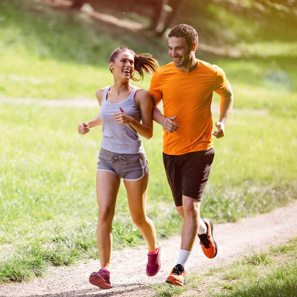 Two people jogging on a grassy path, representing qualities of a healthy relationship in NYC.