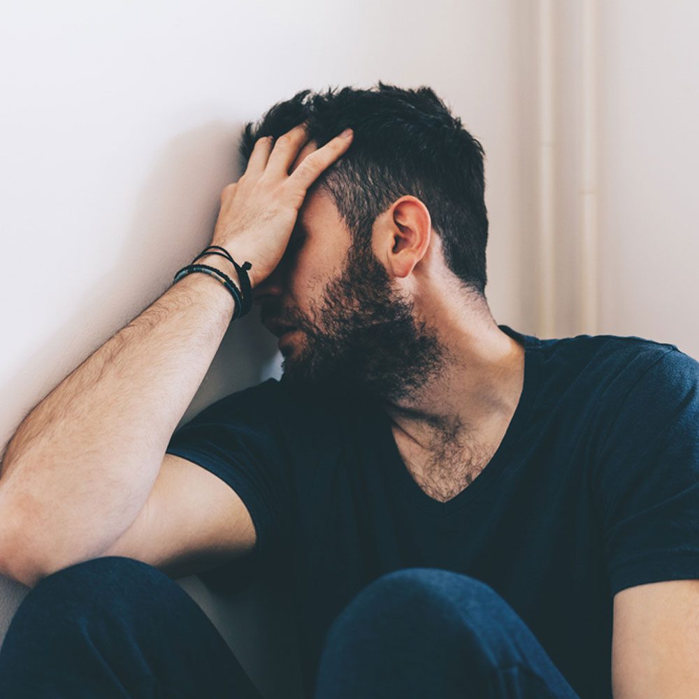 Man looking stressed, reflecting on the effects of growing up with drug-addicted parents in NYC.