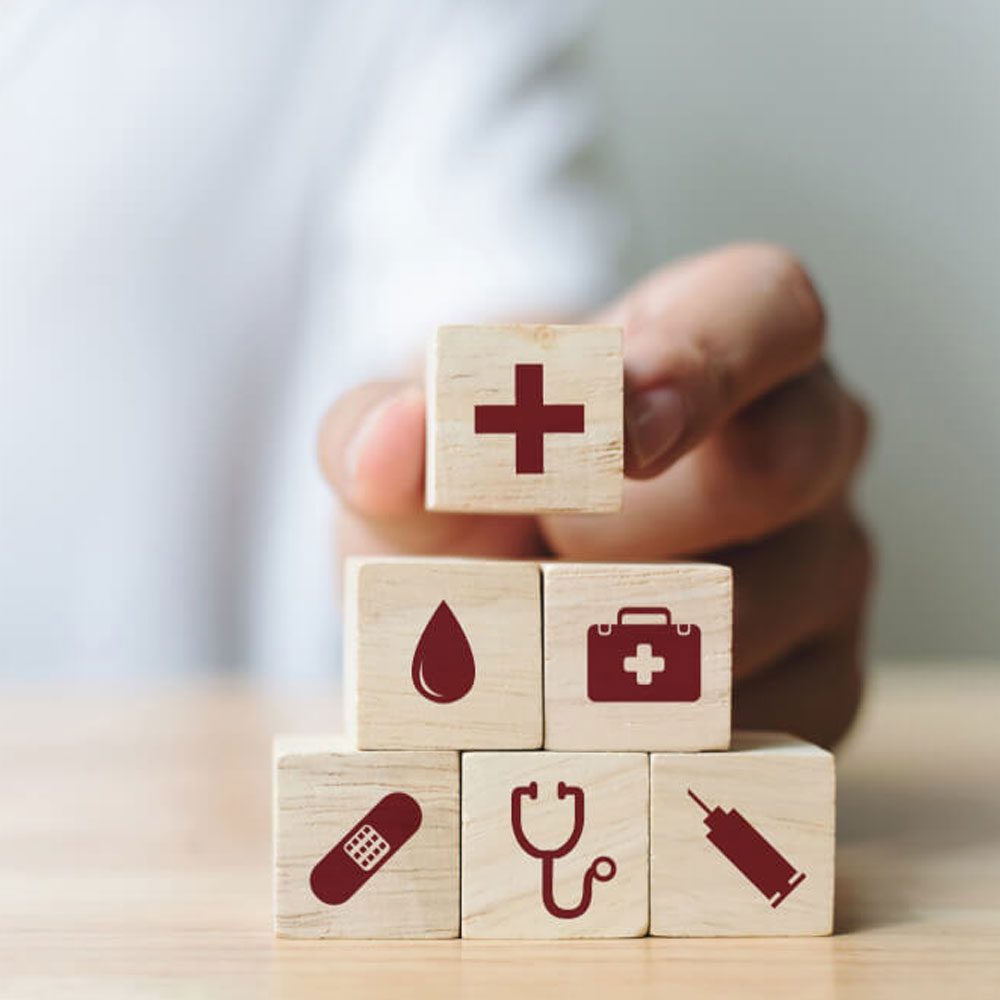 Person stacking blocks with healthcare symbols, discussing NYC therapy and insurance struggles.