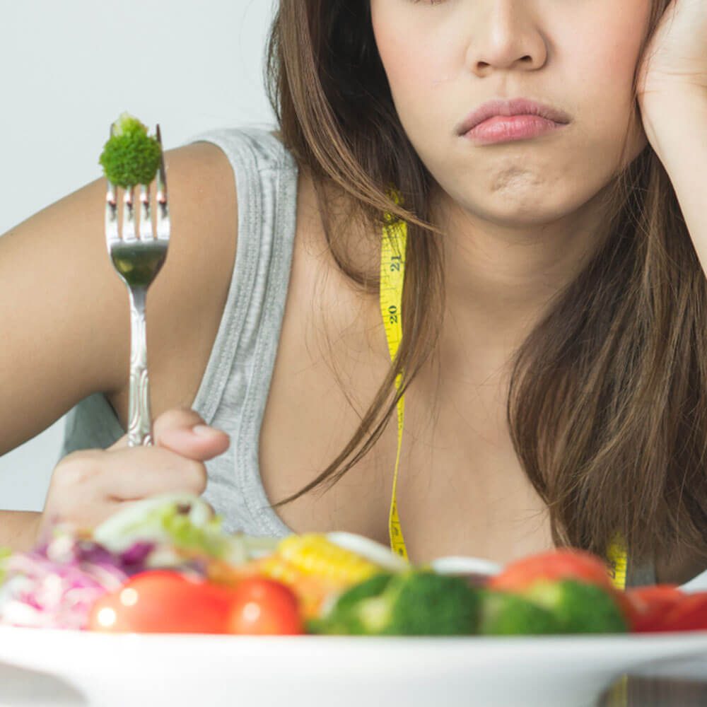 Person holding broccoli, highlighting eating disorder recovery struggles in NYC.