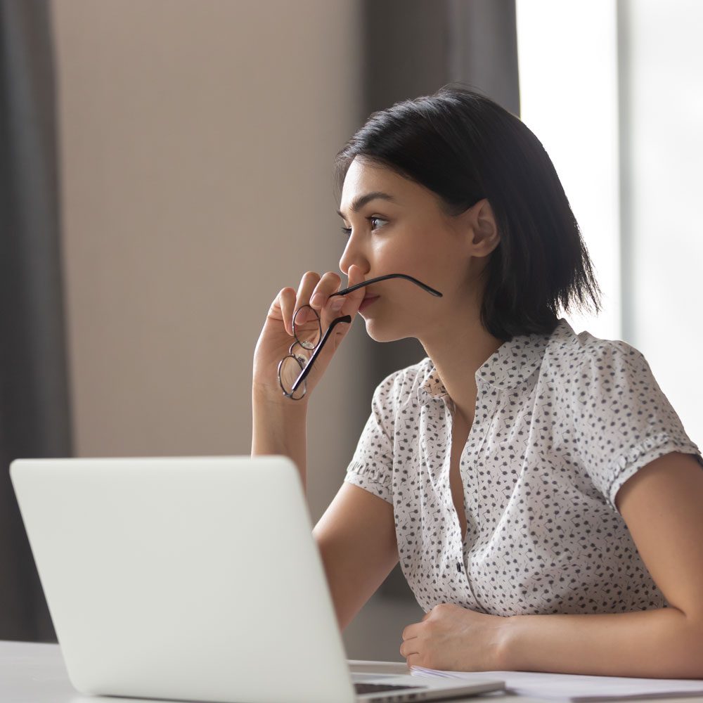 Woman working on a laptop, addressing decision anxiety in NYC - Uncover Counseling.