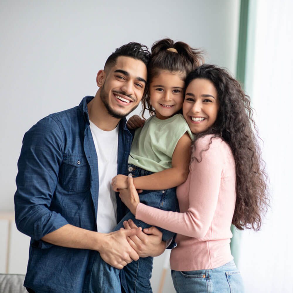 Family with a child embracing in a room, exploring parent-child therapy in NYC - Uncover Counseling.