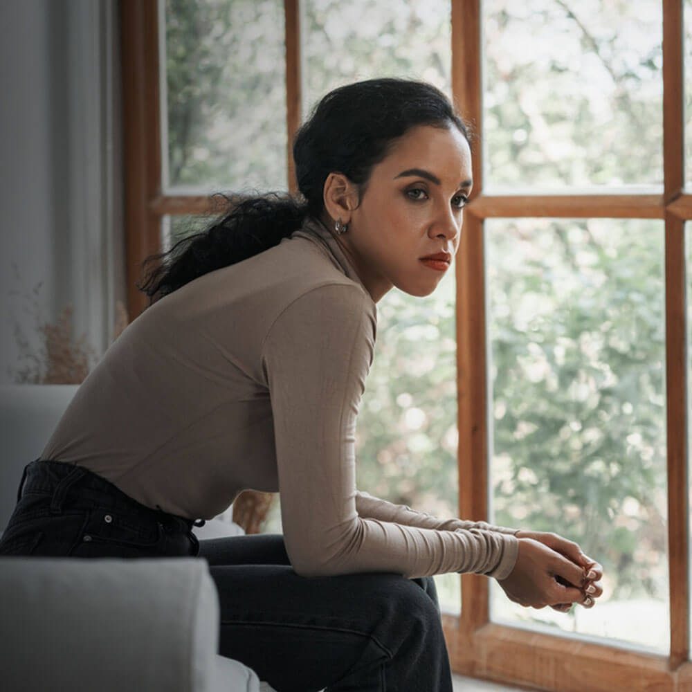 Person by window, natural backdrop, navigating mental breakdowns and recovery in NYC.