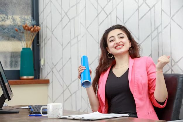 cheerful young lady sitting desk feeling happy