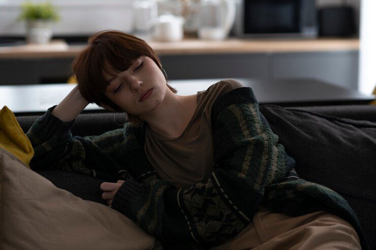 Medium shot woman sitting on couch - does depression make you tired?