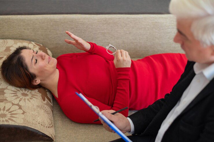 A woman lies on a couch during a psychotherapy session
