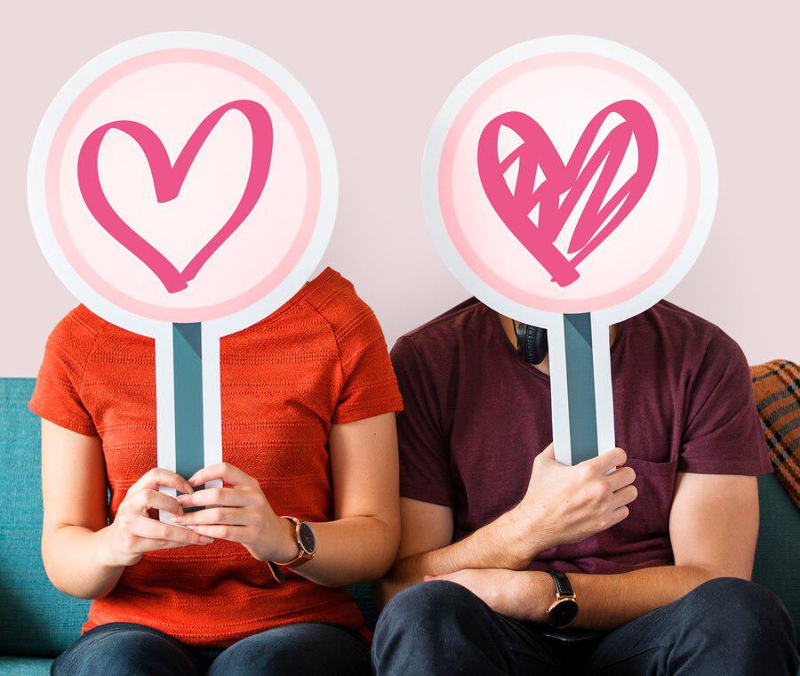 Happy couple holding heart signs