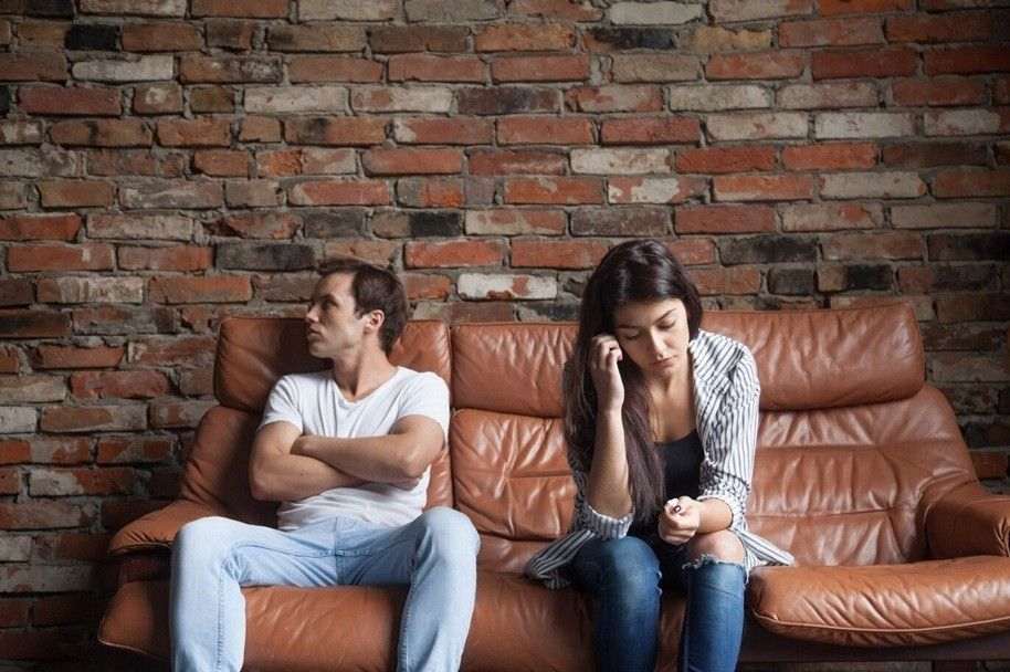 Emotional Reactivity in Relationships Frustrated upset couple after quarrel sitting on sofa at home Uncover Mental Health Counseling
