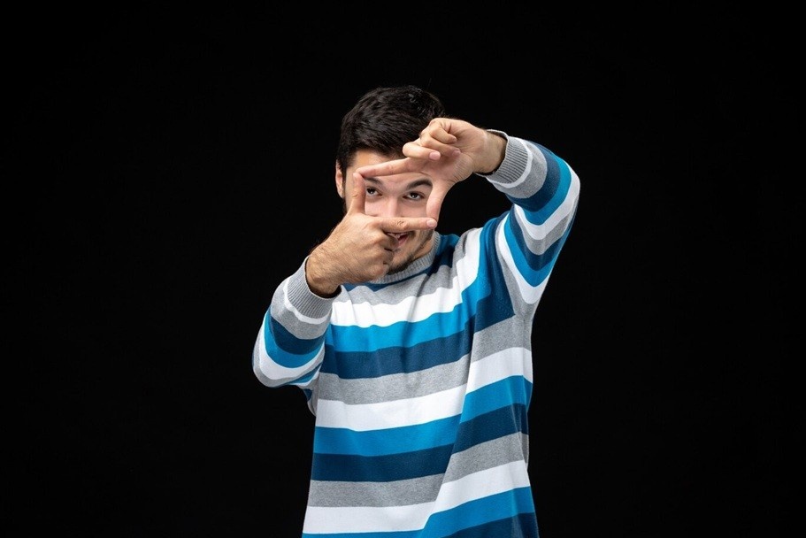 hyperfocus - a young male in blue striped jersey doing frame gesture with hands