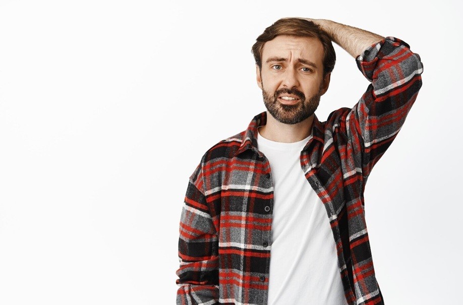 mandela effect - Troubled and confused bearded man holding hand on head