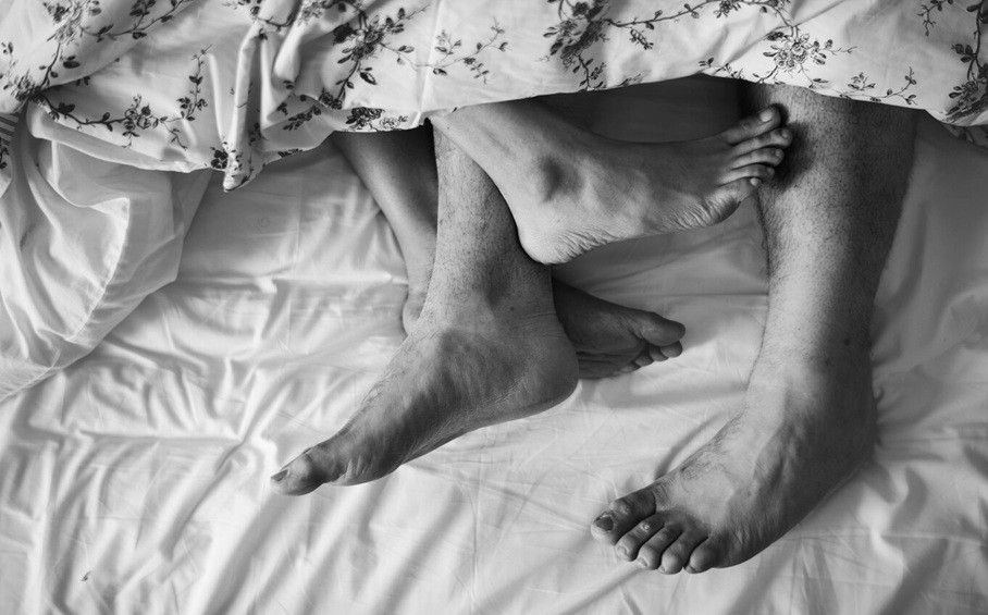 sex addiction symptoms - Aerial view of legs on bed