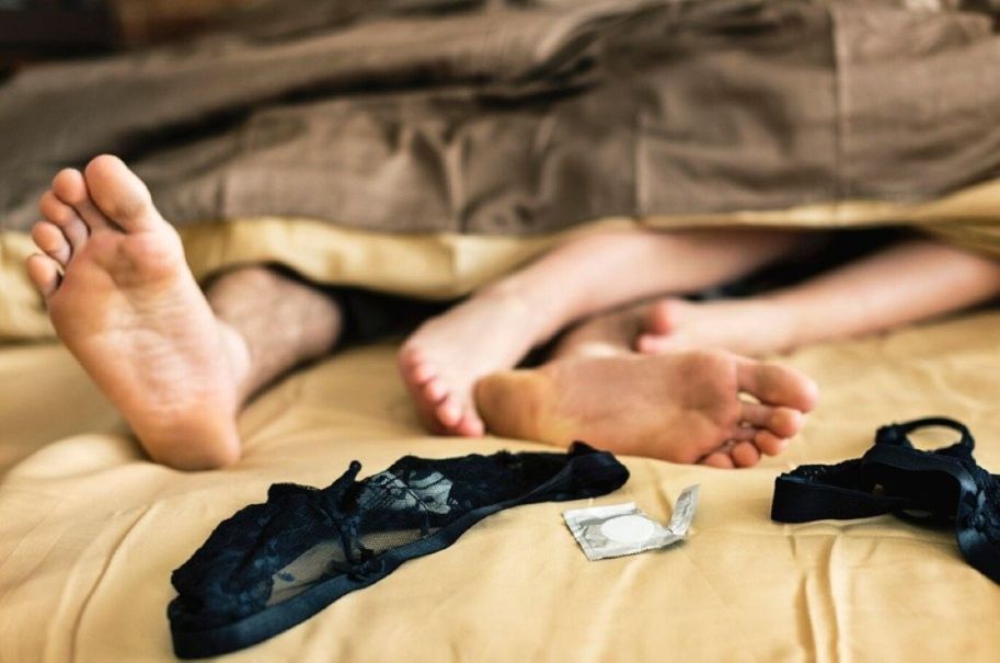 sex addiction symptoms - couple lying on bed together