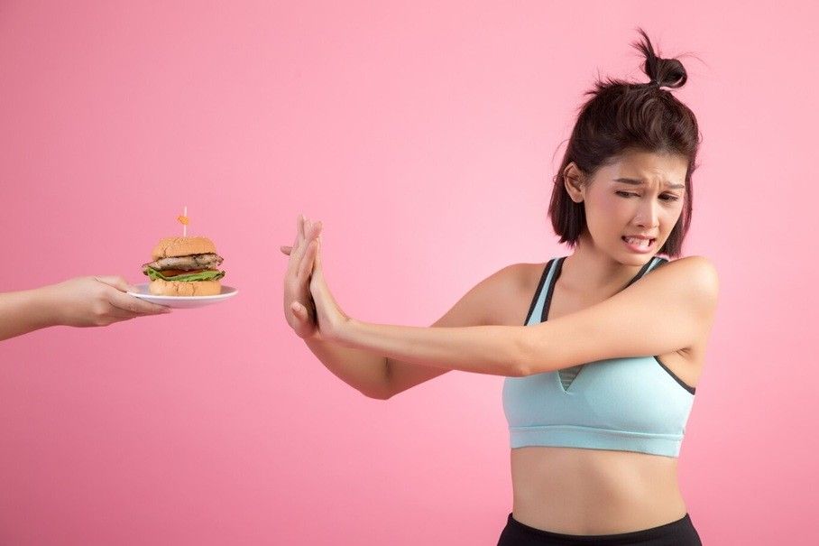 bulimia vs anorexia nervosa - a woman rejecting a delicious burger