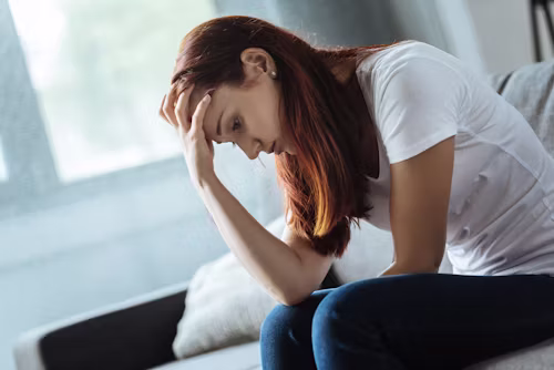 Person sitting alone looking anxious and overwhelmed